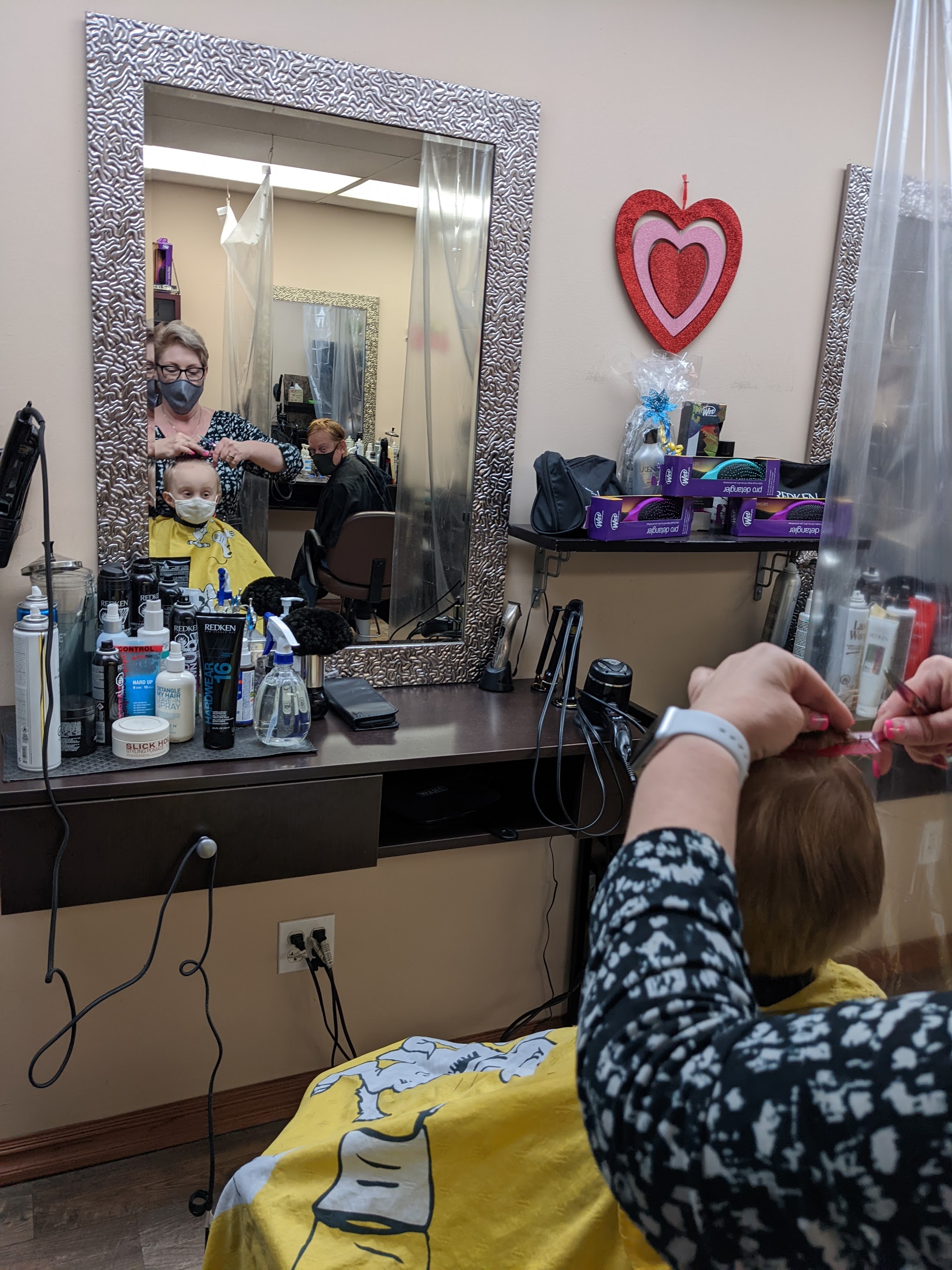 Stylist working at a silver-framed mirror station inside Maryjo's Hair Design